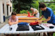 Rainer Sosen, Regina Sanjath beim Wäsche zusammenlegen, ein Zivildiener unterstützt