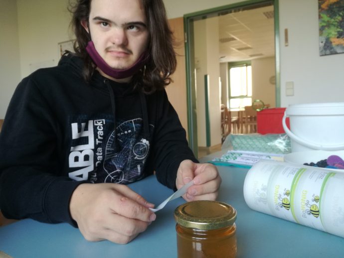 Herr Wejwoda beklebt die Honiggläser mit Etiketten