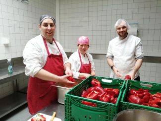 Ein Team aus der Lebenshilfe Wien schneidet Paprika für die Firma Wrapstars