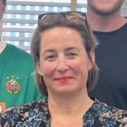 Das Foto zeigt die CEO, Bettina Schuckert, von dentsu Austria im Kreis der Gartengruppe der Lebenshilfe Wien. Alle Personen stehen in der Medienagentur und zwei Herren haben Gießkannen in der Hand, da sie sich wöchentlich um die Grünpflanzen vor Ort kümmern.