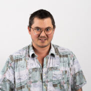 Das Foto zeigt Patrick Galanis, einen Mitarbeiter der Lebenshilfe Wien. Er hat kurze dunkle Haare, eine Brille, schaut freundlich in die Kamera und trägt ein gemustertes Hemd.