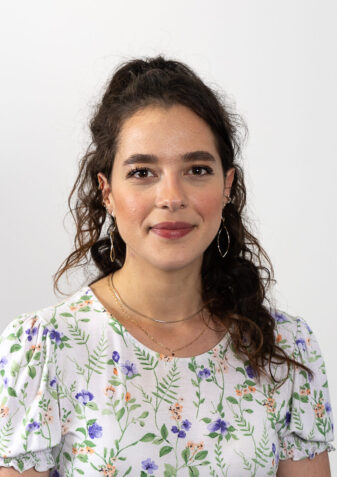 Das Foto zeigt die Verantwortliche in der Lebenshilfe Wien für Personaladministration. Deborah Baranow ist eine junge Frau mit langen zurückgebundenen, dunklen Haaren, sie trägt eine helle, gemusterte Bluse.