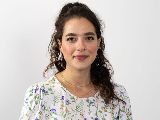 Das Foto zeigt die Verantwortliche in der Lebenshilfe Wien für Personaladministration. Deborah Baranow ist eine junge Frau mit langen zurückgebundenen, dunklen Haaren, sie trägt eine helle, gemusterte Bluse.