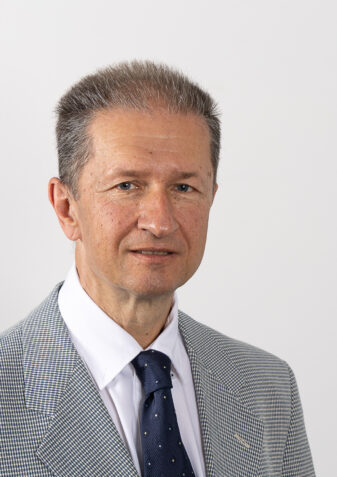 Der Praesident der Lebenshilfe Wien ist Stefan Sedlitz. Er hat kurze graue Haare, traegt ein gemustertes Sakko mit Krawatte und Hemd.