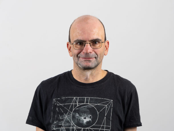Der Mitarbeiter Matthias Papst schaut freundlich in die Kamera. Er ist fuer den Bereich Personenzentrierte Arbeit und Sozialraumorientierung in der Lebenshilfe Wien verantwortlich. Sie hat eine Brille und trägt ein dunkles Oberteil.