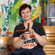 Eine Frau mit modernem Kurzhaarschnitt schaut freundlich in die Kamera