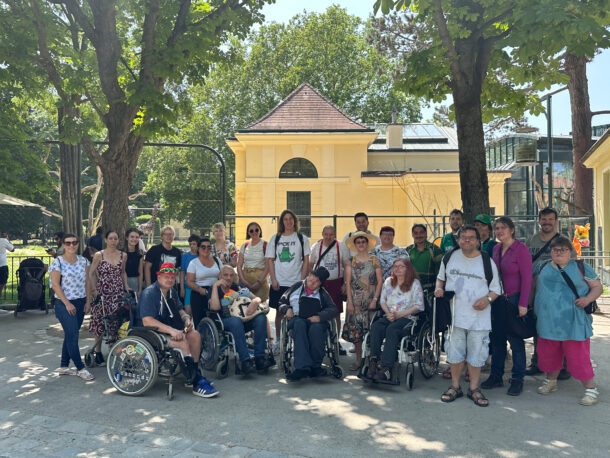 Eine Personengruppe von der Lebenshilfe Wien und der Erste Bank steht vor dem Zooeingang in Schönbrunn zusammen