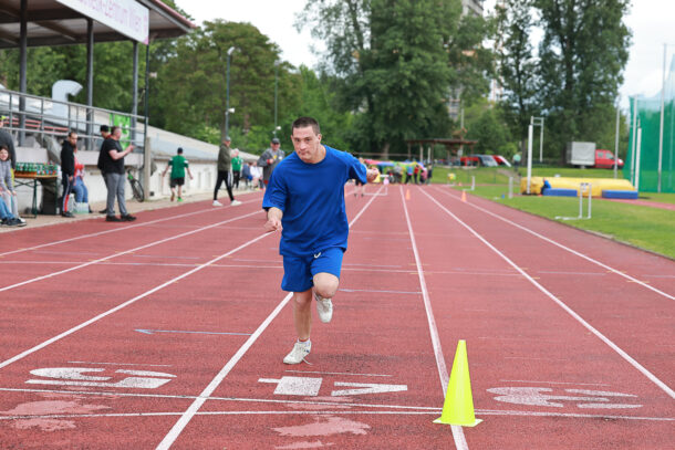 Ein Mann mit blauem Sportgewand läuft auf einer Laufbahn