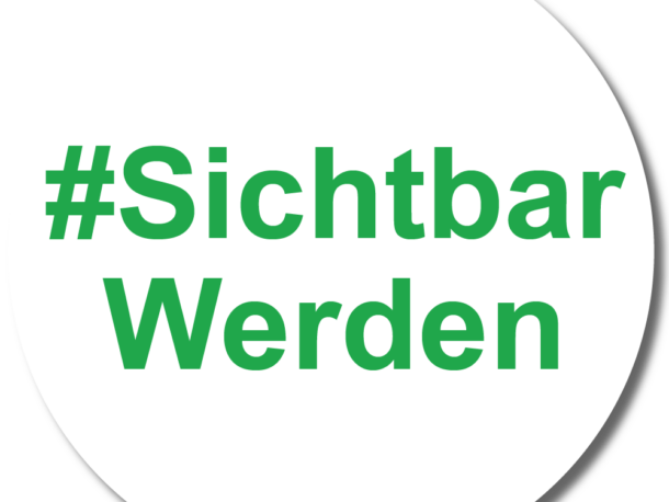 Eine weiße runde Schaltfläche mit dem grünen Text #SichtbarWerden in der Mitte.